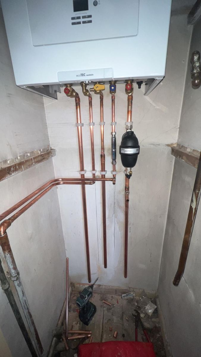 New boiler with neat copper pipework in a cupboard