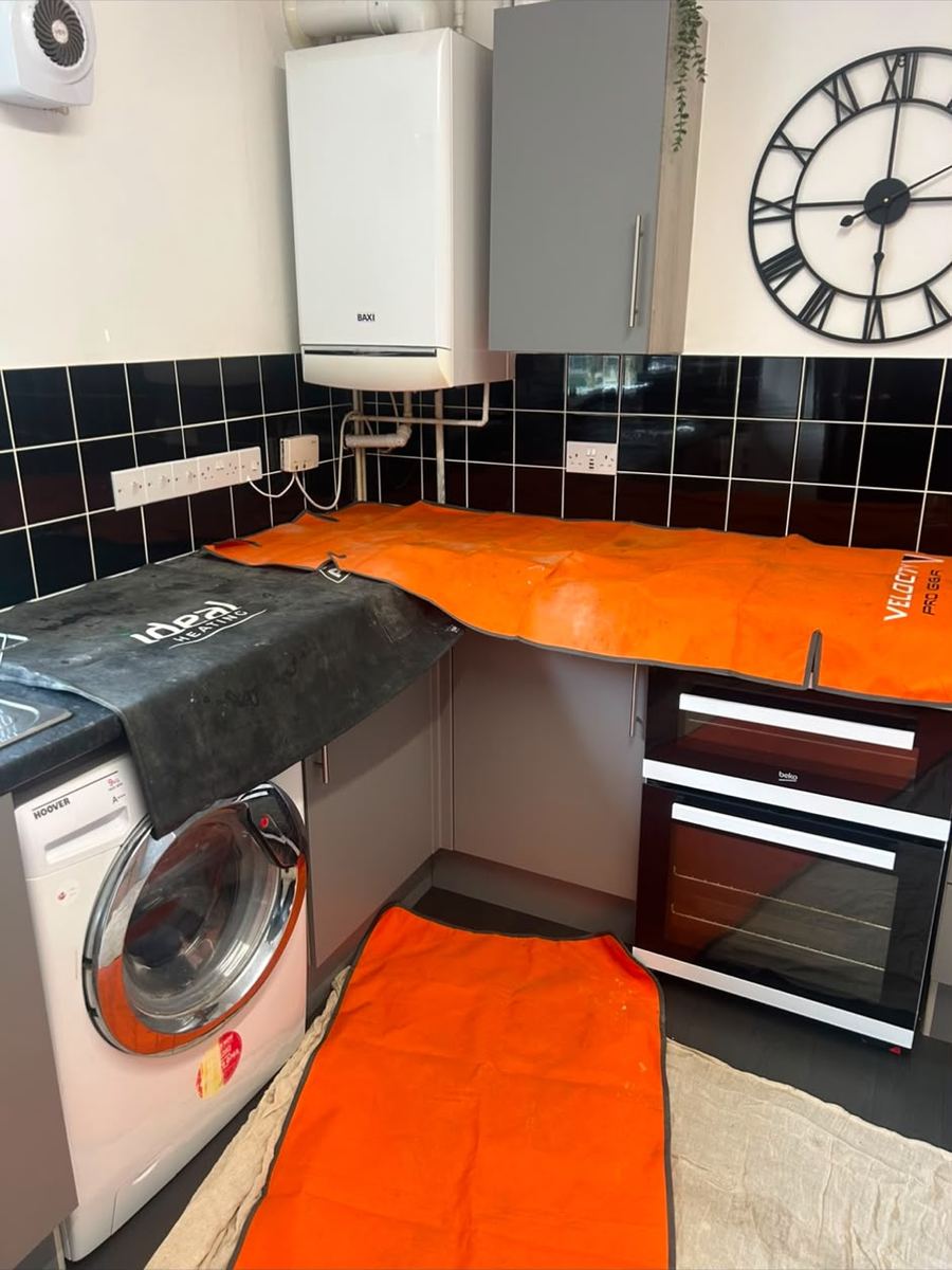 Kitchen protected with floor sheets during a boiler install