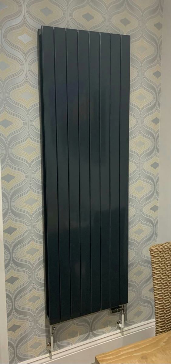 A vertical designer radiator fitted on an internal wall